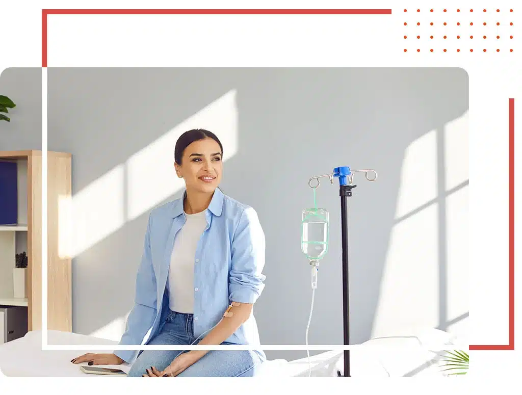 Smiling woman receiving IV therapy in a modern urgent care clinic, representing prompt medical services in Katy, TX.
