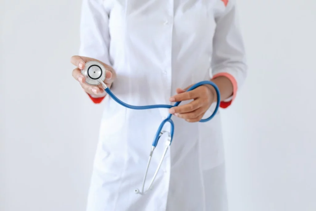Female doctor in a white coat holding a stethoscope, representing compassionate and reliable family care services in Katy, TX.