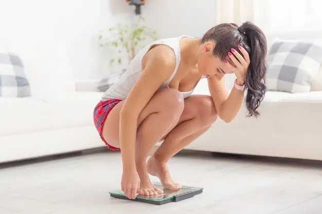 A lady squatting on a scale