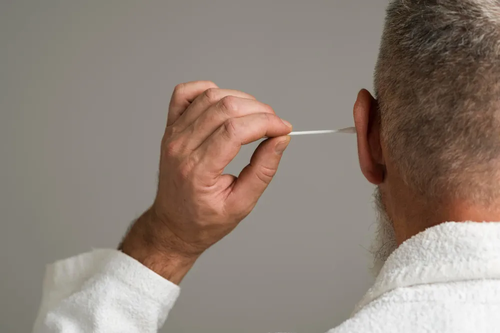 A man using cotton swab in his ear