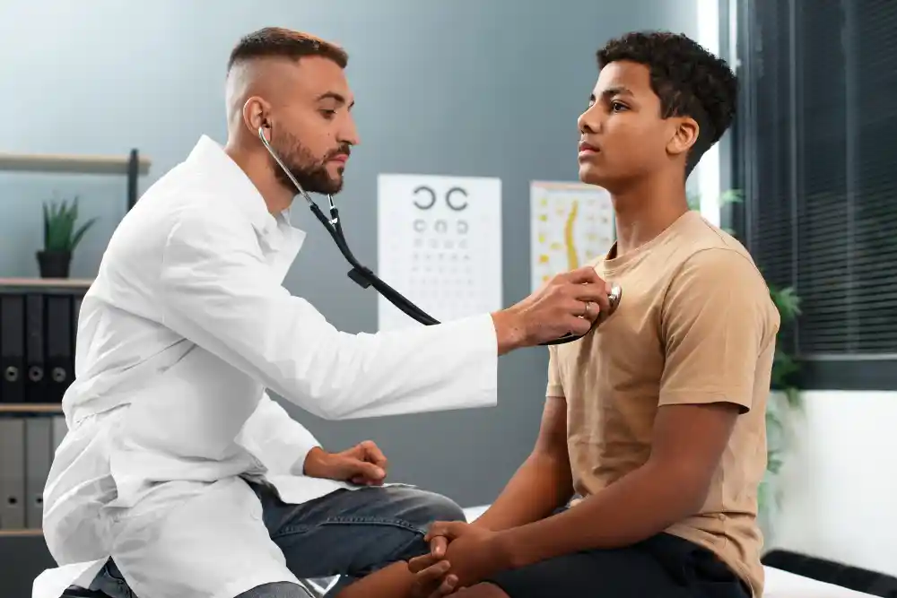 A doctor checking the heart beat of a patient