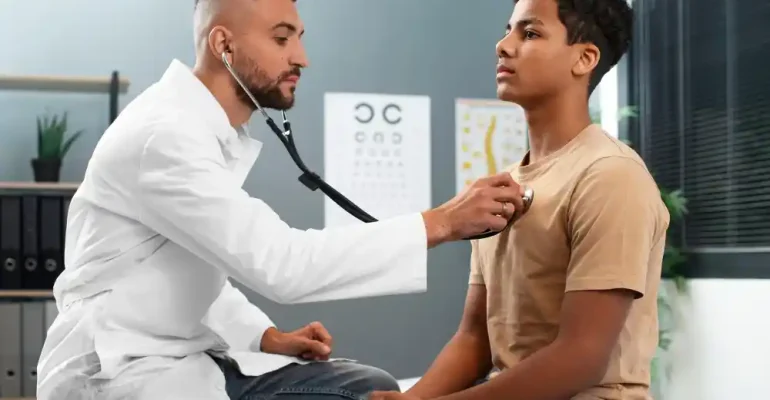A doctor checking the heart beat of a patient